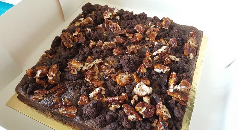 Brownie Streusel et noix pécans Un brownie au bon goût de chocolat surmonté d'une ganache au chocolat noir garnie de billes de chocolat soufflé et de chamallow,