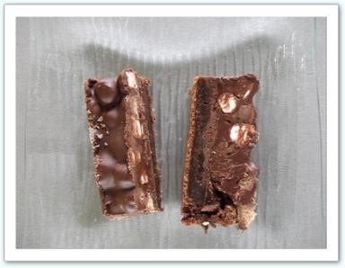 brownie de l'extrême Un brownie au bon goût de chocolat surmonté d'une ganache au chocolat noir garnie de billes de chocolat soufflé et de chamallow,