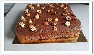 Brownie Fudge Un brownie au bon goût de chocolat surmonté d'une couche moelleuse de fudge aux accents de nutella et décoré de noisettes pour les amateurs de douceur chocolatée !