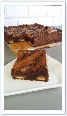 Brownie twix Un brownie riche en texture garni de twix, zébré de caramel au beurre salé et coulis de chocolat.